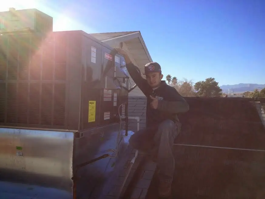 HVAC technician performing Air Duct Cleaning on a rooftop unit in Dearborn
